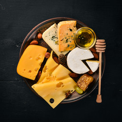 Grapes, red wine, cheeses, honey and nuts on a wooden background. Top view.