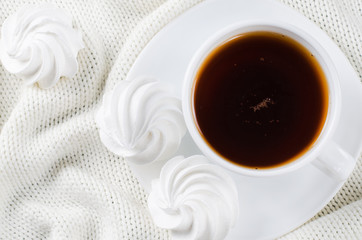Delicious meringue cookies and cup of hot tea.