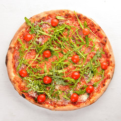 Pizza Primavera. Cherry tomatoes, arugula, cheese. On a wooden background. Top view.