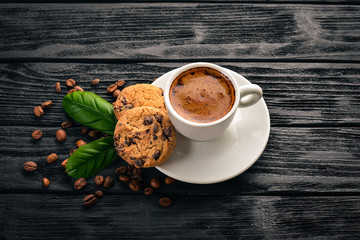 Coffee and oatmeal chocolate cookies on a wooden background. Coffee beans. Top view. Free space for text.
