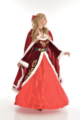 full length portrait of pretty blonde lady wearing red and white christmas inspired costume gown, standing pose on white background.