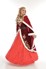 full length portrait of pretty blonde lady wearing red and white christmas inspired costume gown, standing pose on white background.