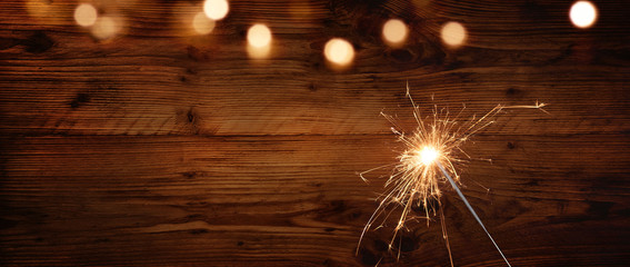 Rustic wooden wall with sparkler and bokeh