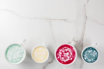 Organic vegan Latte coffee, decaffeinated - turmeric, beetroot, seaweed and matcha. On a white marble background, top view copy space