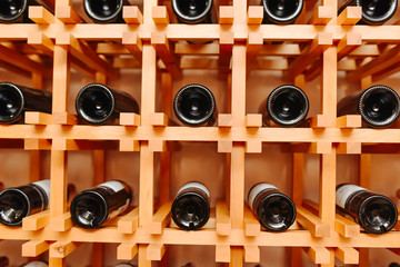 The bottles on the shelves of the wine cellar. Front view