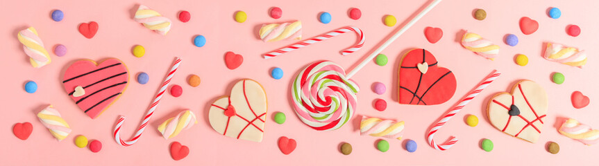 Colorful candies on pink background, top view