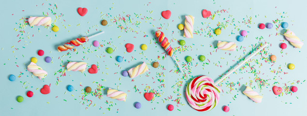Colorful candies on blue background, top view