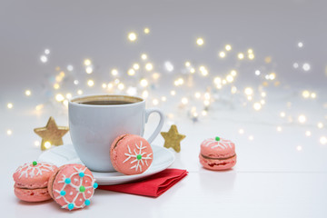 Christmas pink macaroons with garland and coffee cup.