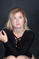 Frau im Body auf Stuhl im Fotostudio