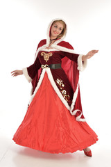full length portrait of pretty blonde lady wearing red and white christmas inspired costume gown, standing pose on white background.