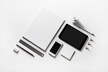 Blank stationery and gadgets at white paper background.