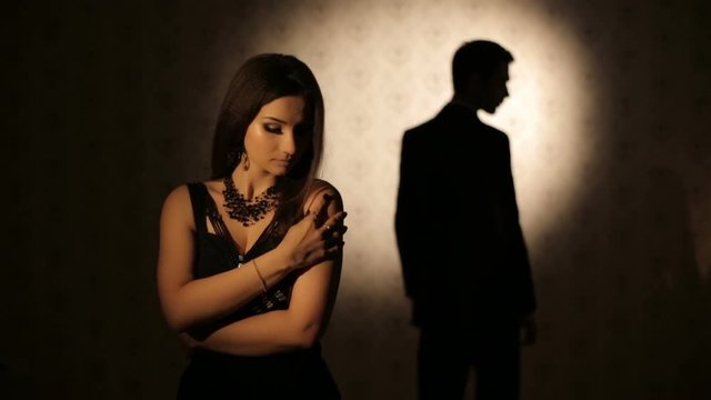 Sad woman and silhouette of a man
