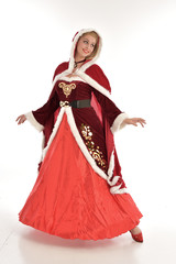 full length portrait of pretty blonde lady wearing red and white christmas inspired costume gown, standing pose on white background.