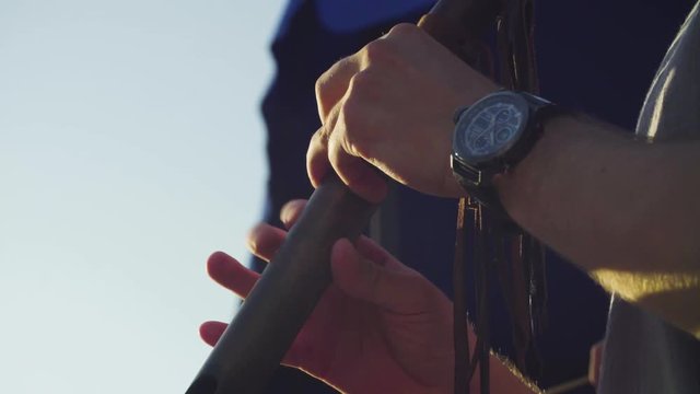 Close up hands of musician playing ethnic flute