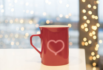 On a dark romantic evening, two mugs stand on the table. The pair in the form of two hearts is rising.
