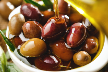 Genuine Italian organic oil cold pressed in slow motion falls on organic bread. concept of nature and healthy food, healthy and natural. fresh olives and Tuscan Italian oil