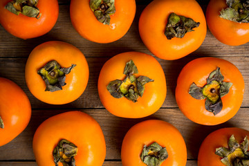 Fresh persimmon fruit on wooden table. Selective focus. Shallow depth of field.