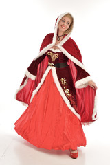 full length portrait of pretty blonde lady wearing red and white christmas inspired costume gown, standing pose on white background.