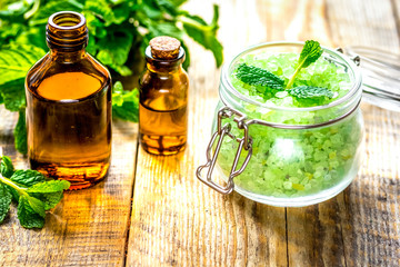organic cosmetics with herbal extracts of mint on wooden backgro