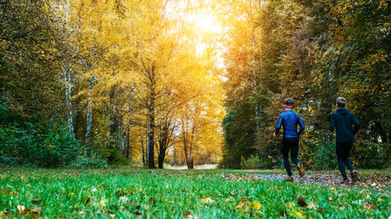 Running athletes in the park on a run in the early morning. Several children are running in the woods doing sports. Healthy lifestyle.