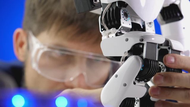 Close up electronics engineer working in lab building and testing robot mechanism.
