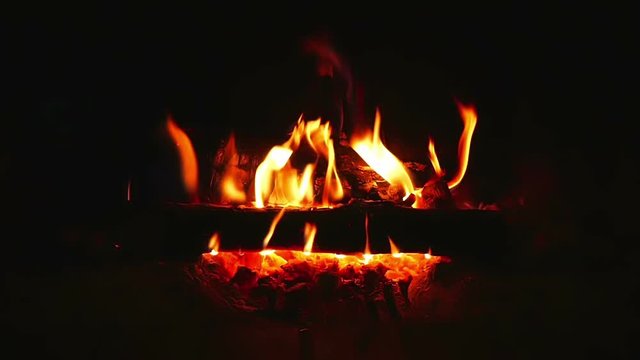 Beautiful warm burning logs in indor fireplace filmed in super slow motion.