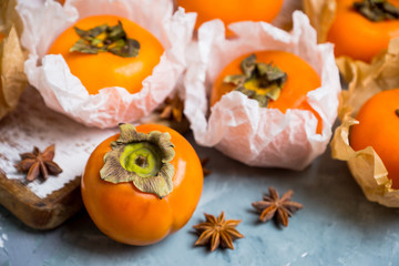 Fresh persimmon fruit on wooden table. Selective focus. Shallow depth of field.