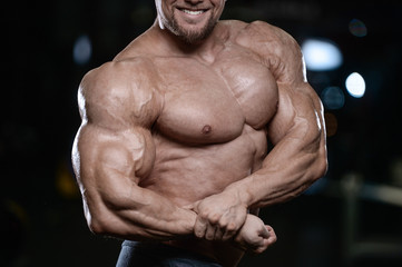 Brutal strong bodybuilder athletic men pumping up muscles with dumbbells.