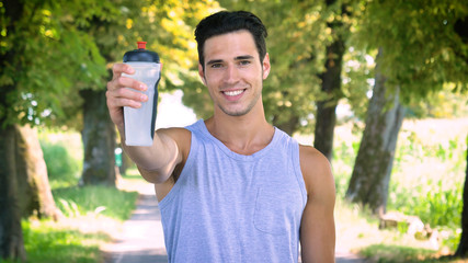 Handsome young guy sportsman drinking an energy drink