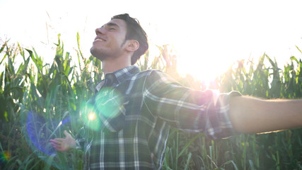 Fototapeta na wymiar Portrait of a beautiful young farmer (student) working in the field with a tractor working in a tablet, happy, in a shirt, corn field. Concept ecology, transport, farmers, clean air, food, bio product