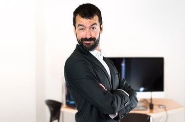 Handsome businessman with his arms crossed in the office