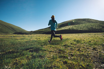 young fitness woman trail runner running outdoors
