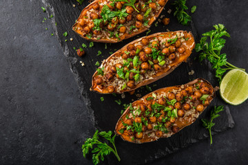 roasted sweet potato stuffed with chickpeas and quinoa. Top view. black background