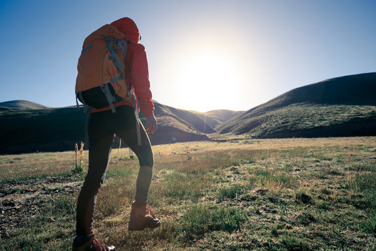 backpacking woman hiker hiking in sunrise mountains