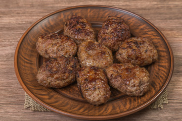 Homemade cutlets of meat in a ceramic bowl close-up. Brown