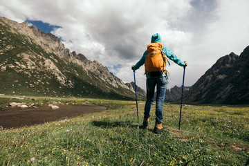 one backpacking woman hiking in the high altitude mountains