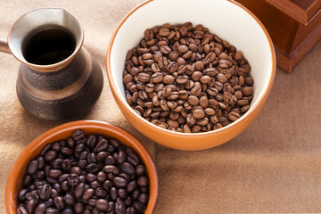 Fototapeta premium two different types of coffee beans with different roast in cups and cezve - coffee pot on a white background
