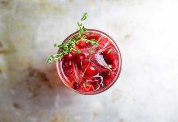 Christmas cocktail with berries and thyme on the rustic background. Selective focus.