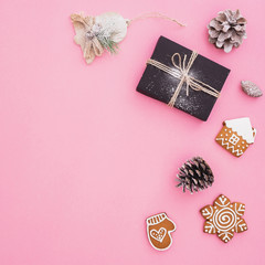 Christmas gift box, gingerbread, decoration and pine cones on pink background. New year concept. Flat lay. Top view
