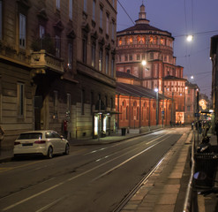 a street in Milan during the Christmas period, with the illuminated church, Santa Maria delle Grazie