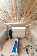 Garage doors installation.Workers installing lifting system