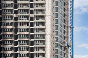 Crane and building under construction against blue sky