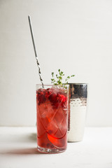Christmas cocktail with berries and thyme on the rustic background. Selective focus.