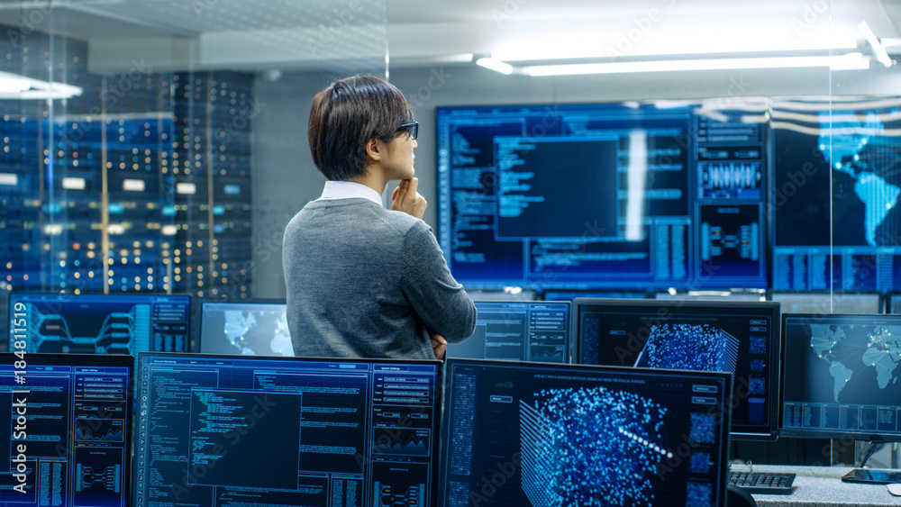 Poster In the System Control Room Technical Operator Stands and Monitors Various Activities Showing on Multiple Displays with Graphics. Administrator Monitors Work of  Artificial Intelligence.