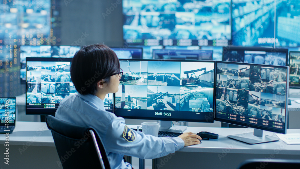 Fototapete in the security control room officer monitors multiple screens for suspicious activities, he drinks 