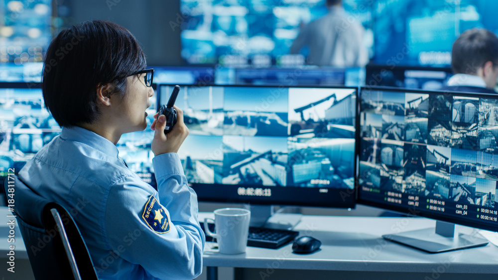 Poster in the security control room officer monitors multiple screens for suspicious activities, he reports