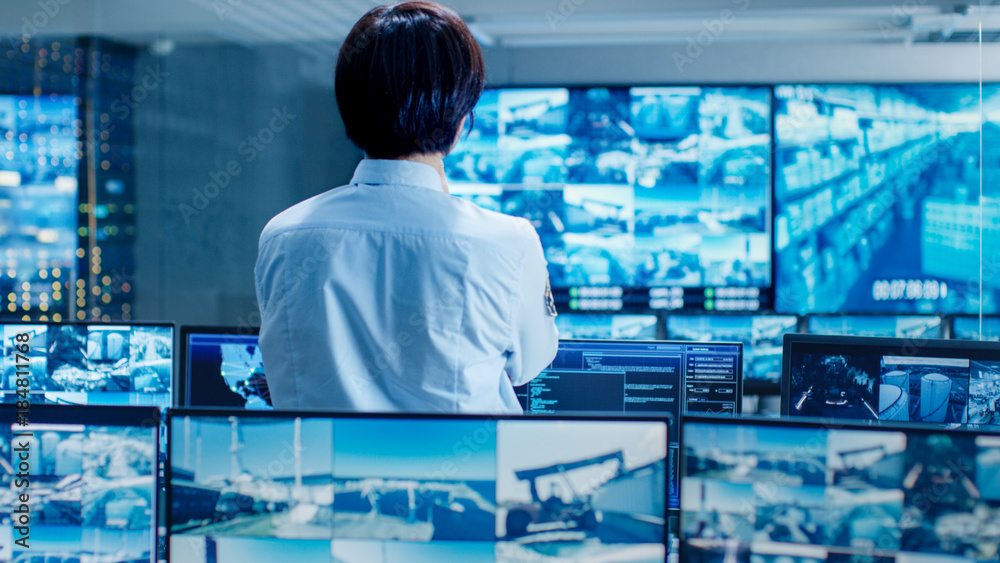 Aufkleber in the security control room officer monitors multiple screens for suspicious activities. he guards 