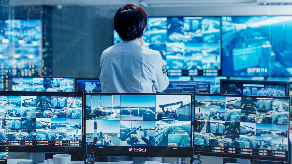 Poster In the Security Control Room Officer Monitors Multiple Screens for Suspicious Activities. He Guards Internationally Important Logistics Facility.