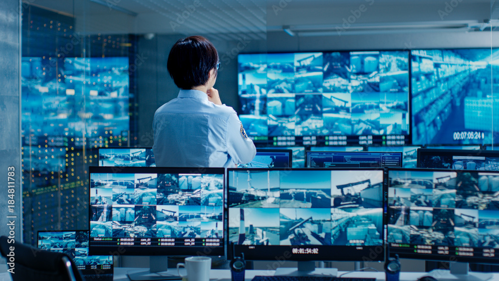 Aufkleber in the security control room officer monitors multiple screens for suspicious activities. he guards 