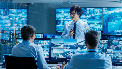 In the Security Control Room Chief Surveillance Officer Briefs Two of His Subordinates. Multiple...